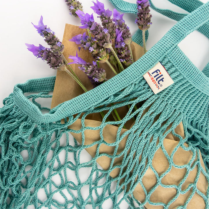 filt string bag in aquablue styled with lavender flowers