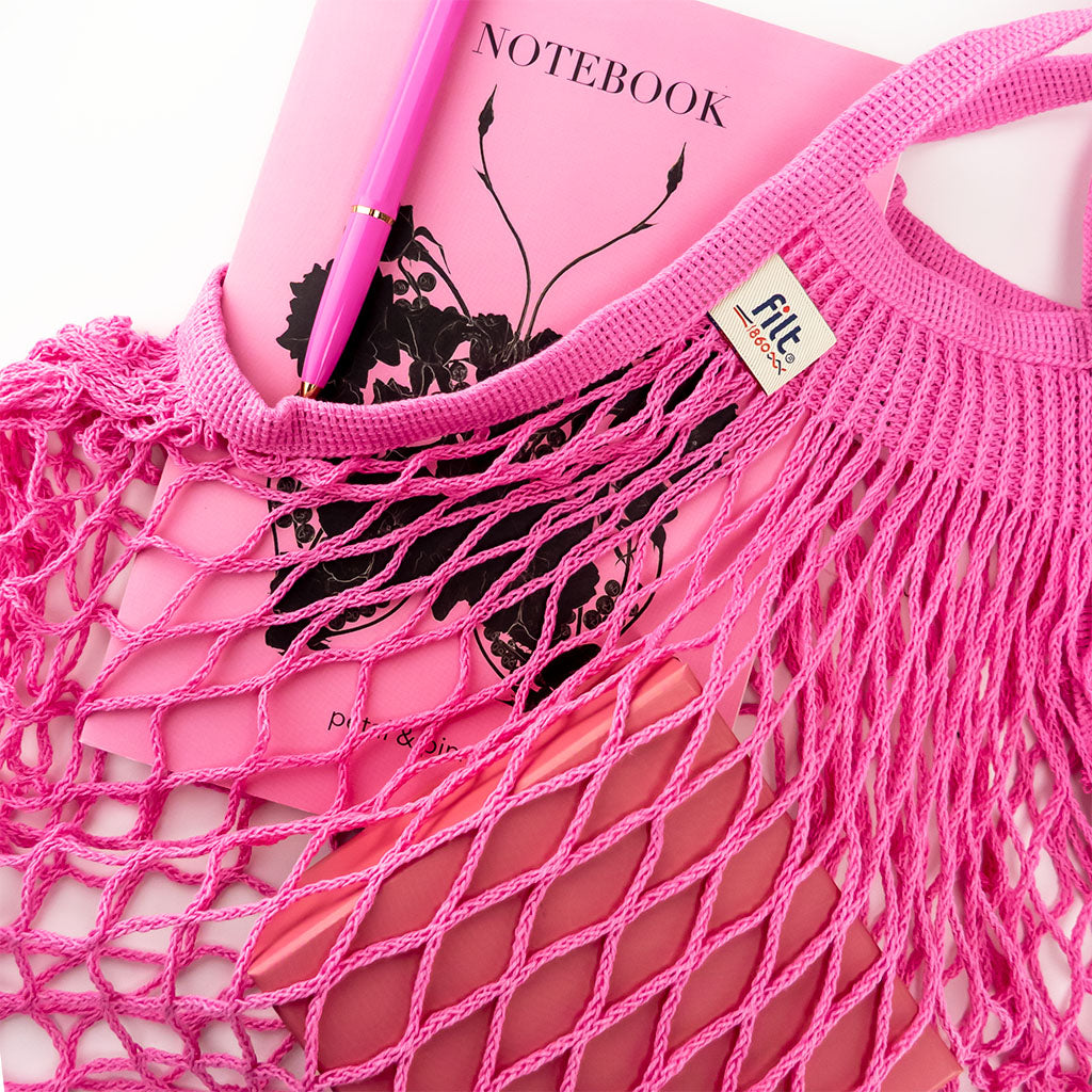 filt string bag in rose sorbet styled with a petal & pins notebook and ballograf pen