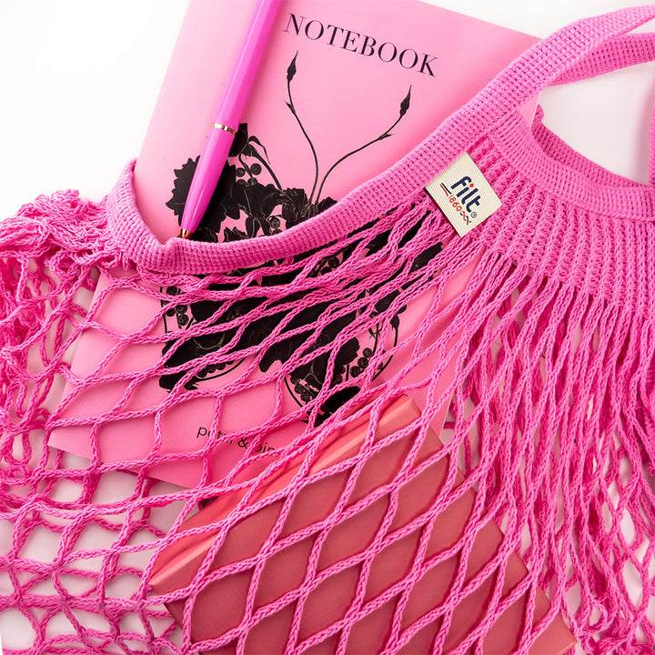 filt string bag in rose sorbet styled with a petal & pins notebook and ballograf pen