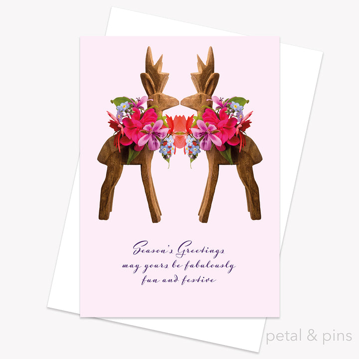 Greeting card with floral reindeer design and 'Season's Greetings' text on a pink background by petal & pins.